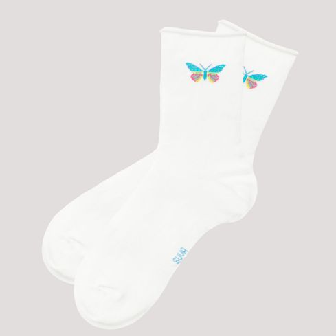 Valged sokid pehme äärega ja väikese liblikaga väike SUVA logo tallal